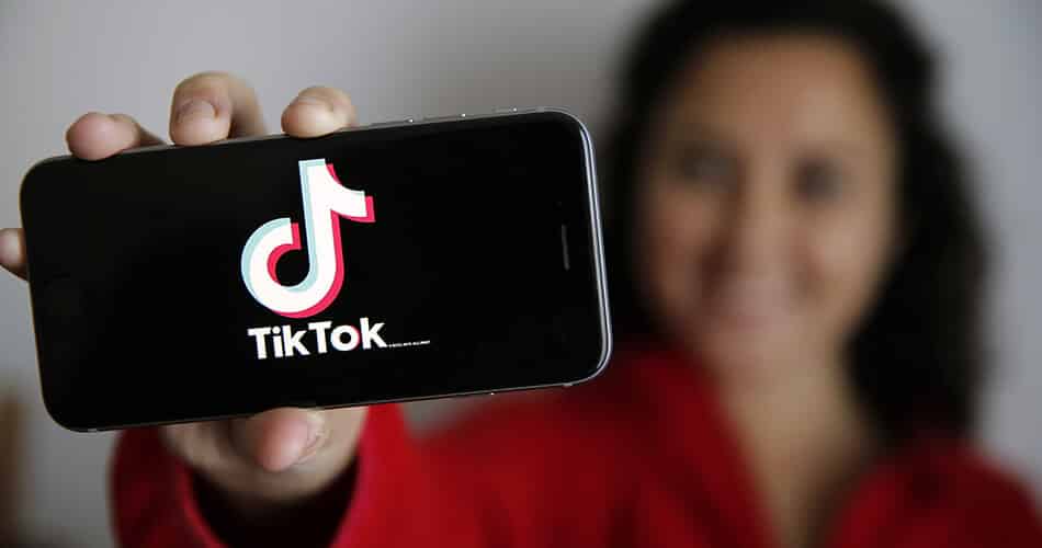 Girl Holding Phone with TikTok Logo